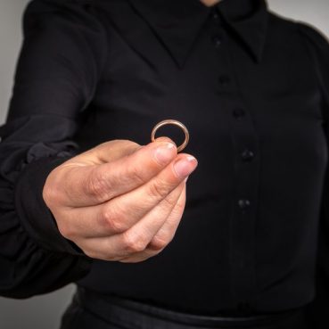 Woman returns the wedding ring. Divorce, division of property and children, assistance of lawyers and consultants concept. Black shirt